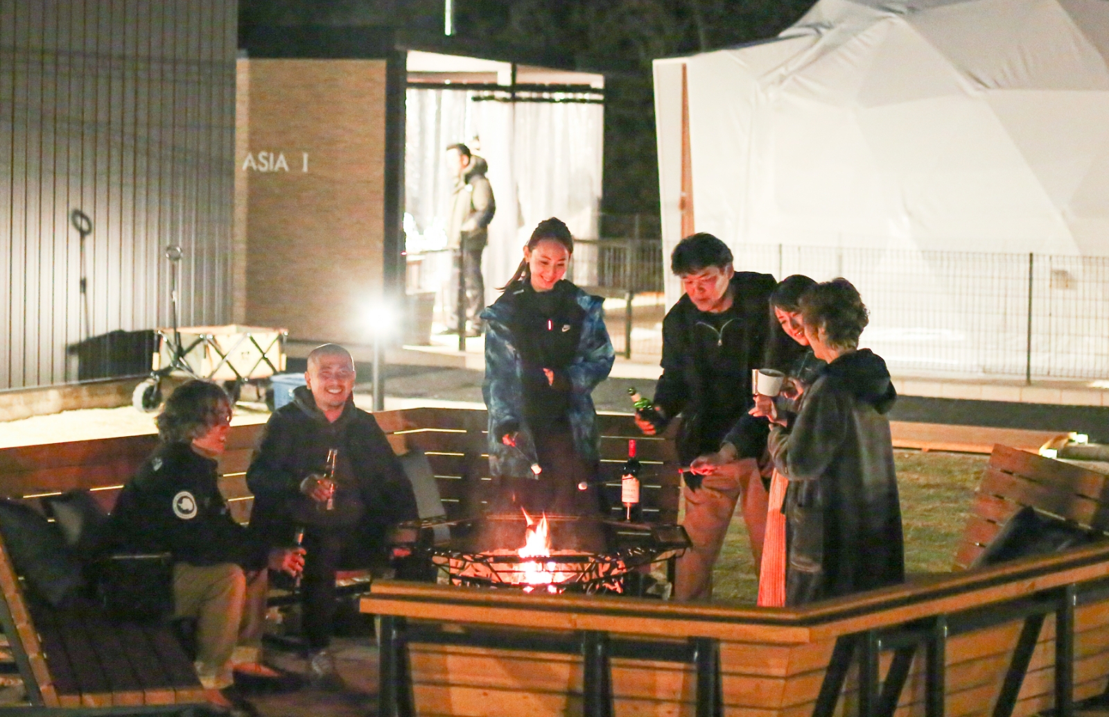 キャンプファイヤーを囲むイメージ写真